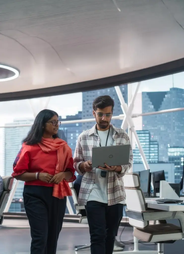 Professional team discussing website design on laptop in modern office – expert website design and development services in Dhaka